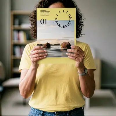 Eine Frau hält das Urlaubszeiten Magazin vor ihr Gesicht.